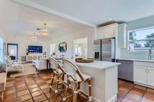 a kitchen and living room with a counter and chairs at The Glenn House - Gather Poolside in a Breezy South End Getaway in West Palm Beach