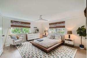 een slaapkamer met een bed, een stoel en ramen bij Northwood Haven - Light-Filled Bungalow Close to Rybovich Marina in West Palm Beach +6 foto's