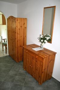 a vanity with a mirror and a vase of flowers on it at Lichtlmühle in Emmersdorf an der Donau