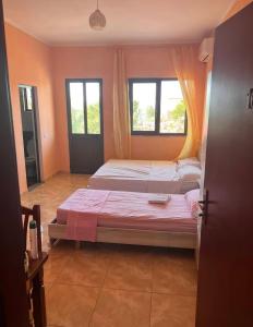 two beds in a room with two windows at Hotel Marino in Baks-Rrjoll