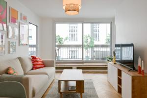 a living room with a couch and two windows at We Parisian Vanneau Cozy Home in Paris