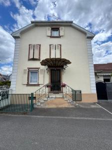 a large white building with a front door and stairs at Au pays des bretzels in Horbourg