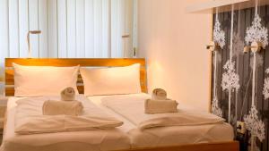 a white bed with two towels on top of it at Frische-Brise-07-03 in Cuxhaven