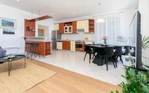 a kitchen and living room with a black table and chairs at Apartment Ljerka in Postira