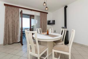 a dining room with a white table and chairs at House Ivan in Prigradica