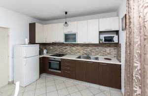 a kitchen with brown cabinets and a white refrigerator at House Ivan in Prigradica