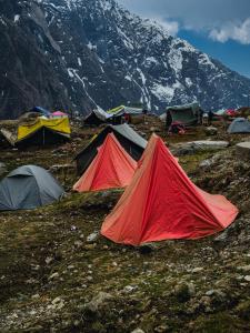 a group of tents on a field with a mountain at Kedar valley camping in Kedārnāth
