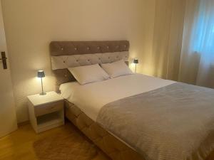 a bedroom with a large bed with a night stand at Apartman MARIJA in Bosanski Šamac
