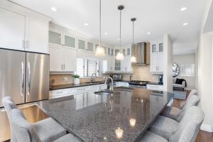 cocina con armarios blancos y encimera de granito en Family-Friendly 3BR Home, en Vancouver