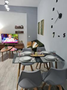 a living room with a table and chairs and a tv at Amyrissa House in Mesochórion