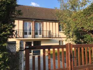 a house with a wooden fence and a balcony at Villa shamina piscine sauna 3 bedrooms in Blonville-sur-Mer