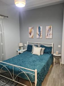 a bedroom with a bed with a blue comforter at Amyrissa House in Mesochórion