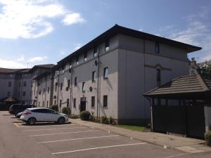 un bâtiment avec une voiture garée sur un parking dans l'établissement Aberdeen Serviced Apartments - Bloomfield, à Aberdeen