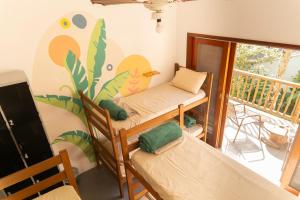 a room with three bunk beds and a balcony at Marola Hostel in Ubatuba