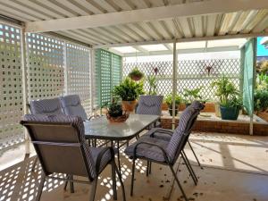 a patio with a glass table and two chairs at Bellavista in Tiddy Widdy