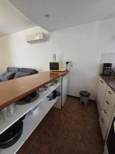 a kitchen with a wooden counter top in a room at Apto 1 dormitorio, pleno centro de Colonia in Colonia del Sacramento +6 photos