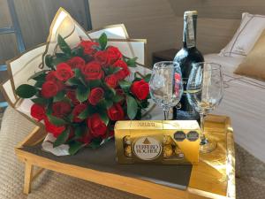 a table with a bouquet of red roses and wine glasses at Cádiz Hotel Boutique in Villa de Leyva
