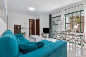 un salon avec un canapé bleu et une salle à manger dans l'établissement Santa Úrsula 21, à Costa Calma