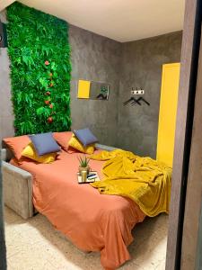 ein Schlafzimmer mit einem Bett mit einer grünen Wand in der Unterkunft Chambre Coté Terre & Coté Mer in Cuxac-dʼAude