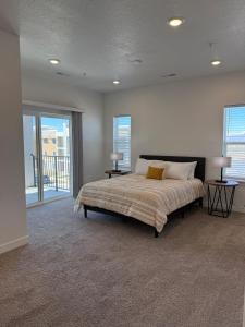 una camera da letto con un grande letto con due lampade su due tavoli di Brand New Condo in Spanish Fork a Spanish Fork Altre 12 foto