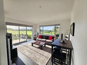 a living room with a couch and a table at Luxury B&B Steps Away From Most Wedding Venues of Kumeu! in Kumeu
