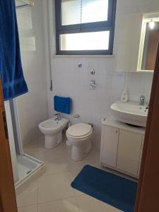 a white bathroom with a toilet and a sink at Il Giardino Ideal for all seasons in Trapani +16 photos