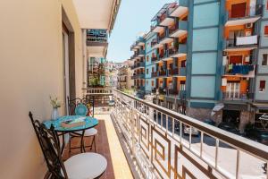 a balcony with a table and chairs and buildings at Casa BoMa in Minori