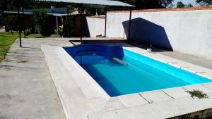 a blue swimming pool in a yard next to a building at Pequeño Complejo Pachamama - Casa Sol in San Antonio +12 photos