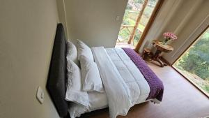 A bed or beds in a room at Amaru TreeHouse