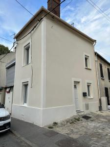 a white house with a car parked in front of it at Raffinement Absolu in Saulx-les-Chartreux