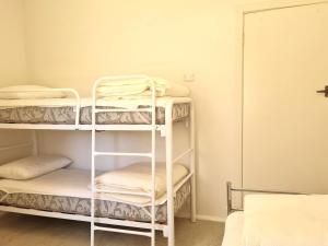 a room with three bunk beds and a room with a door at Catalina Cottage in Port Moonta