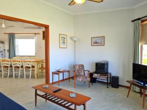 a living room with a couch and a tv at Catalina Cottage in Port Moonta