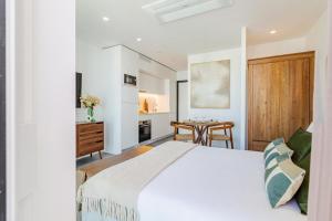 a bedroom with a white bed and a dining room at Timeless Studio - Avenida in Aveiro