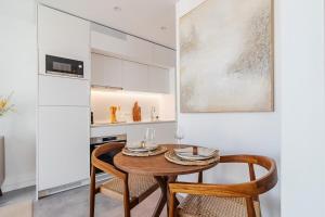 a kitchen with a wooden table and two chairs at Timeless Studio - Avenida in Aveiro +9 photos