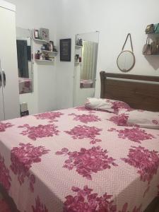 una camera con un letto con una coperta rosa e bianca di Luar a São Thomé das Letras