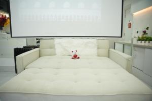 グルガオンにあるLeModCasa Pearl house, Smart luxurious comfortの白いベッド(テディベア付)