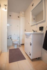 ein Badezimmer mit einem weißen Waschbecken und einer Toilette in der Unterkunft Solpor de Pedras Negras in San Vicente do Mar