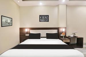 a bedroom with a large white bed and a desk at Super Townhouse Kankarbagh Formerly Kunwar Alcajars in Patna