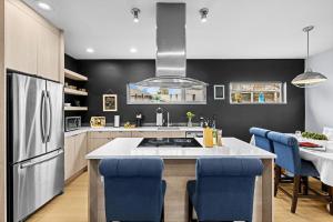 une cuisine avec un comptoir blanc et des chaises bleues dans l'établissement Perch - Indo Haven, à Seattle