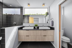 une salle de bain avec deux lavabos et un miroir dans l'établissement Perch - Indo Haven, à Seattle 40 autres photos