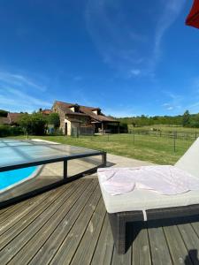 a bed sitting on a deck next to a pool at Peaceful, comfortable retreat with pool in Montcléra