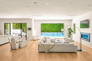 ロサンゼルスにあるLuxurious Retreat - Modern House with Poolの白い家具と大きな窓のあるリビングルーム