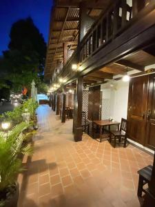 an outdoor patio with a table and chairs at night at Luang Prabang Golden Lotus Villa River View in Luang Prabang