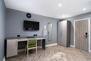 a living room with a desk and a green chair at Hotel LIV in Birmingham +8 photos