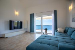 a living room with a blue couch and a tv at Villa Danijela with private Jacuzzi and parking in Vinišće