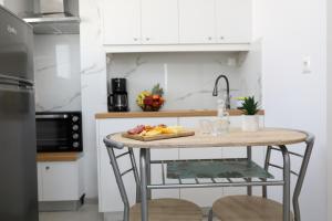 a kitchen with a table with a plate of food on it at Andrieli Suite in Analipsi +18 photos