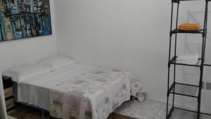 a small bedroom with a bed and two shelves at Apt no Menino Deus in Porto Alegre