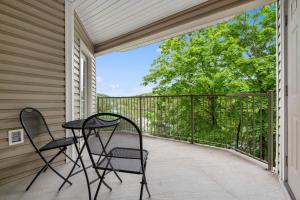 a patio with two chairs and a table on a balcony at Lake It Easy - Condo for 7 in Kimberling City +16 photos