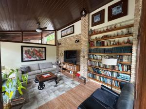 a living room with a couch and bookshelves at Toca do Camarão in São Sebastião