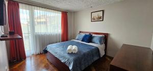 a bedroom with a bed with two white shoes on it at Mirador Calle Larga - anti-ruido in Cuenca +10 photos